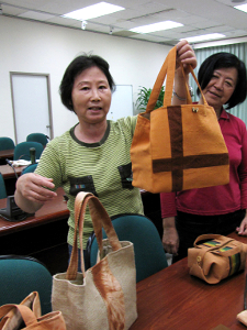 近日榮升課長的陳秀蓉（左）秀出班員的麻芛染織作品（洪翠蓮攝影）